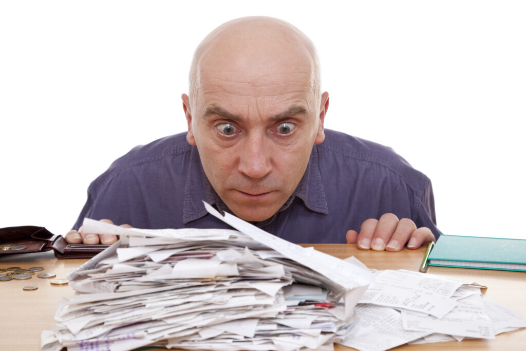 man looking at a pile of credit card receipts